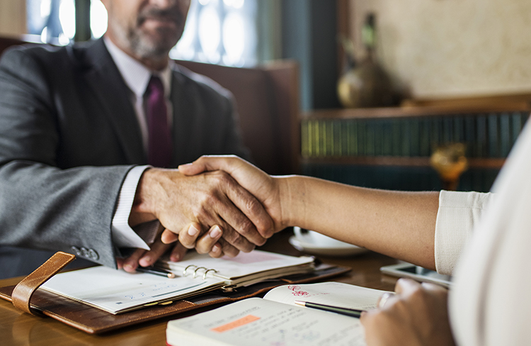 Financial advisor shaking hands with a client during a meeting